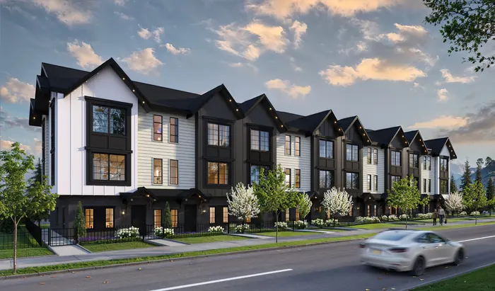 Artist’s rendering of the Bromley townhome row with white and black facades, gables and brick at the base, along a street with a passing car