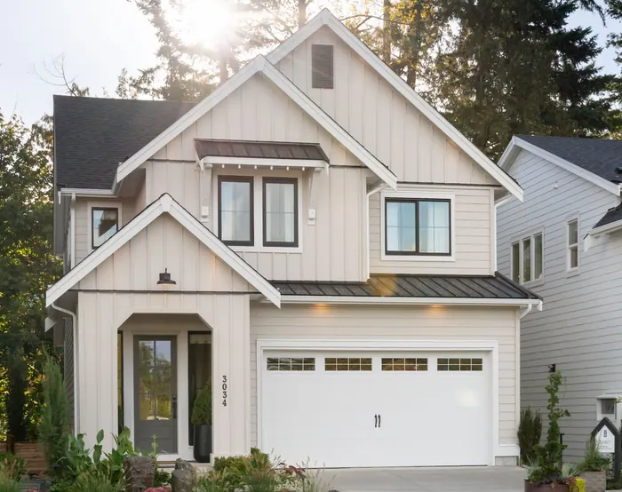 A cream two-storey house with board-and-batten siding and a double garage at 3034 Brigette Street