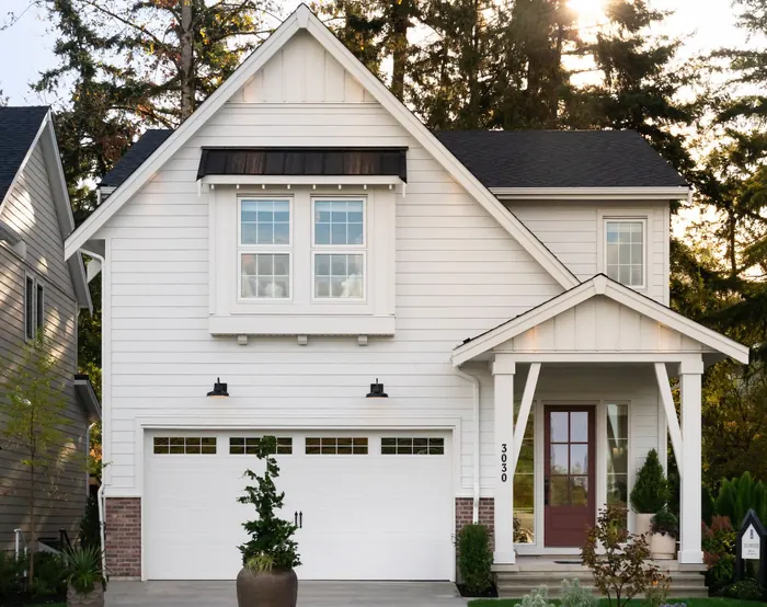 A white two-storey house with a covered front porch and a double garage at 3030 Brigette Street
